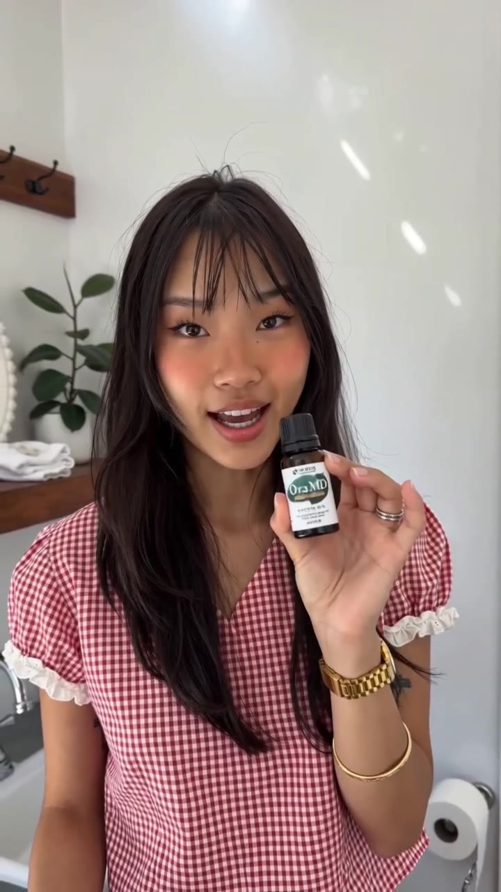 AI-generated presenter holding the OraMD Tooth Oil bottle
