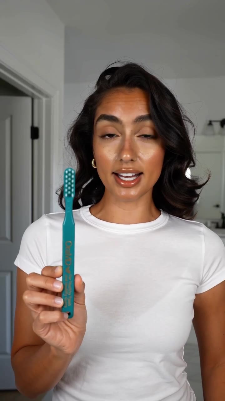 AI-generated presenter holding the OraMD Dr. Bass toothbrush
